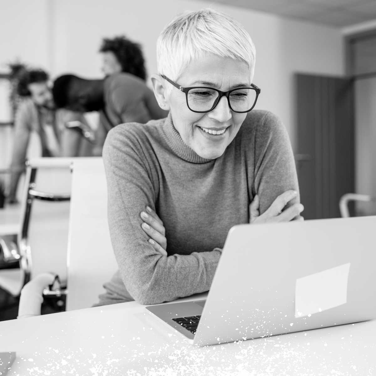 一個面帶微笑的女人看著筆記型電腦